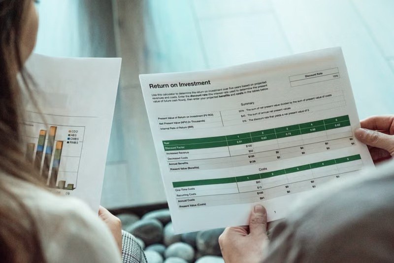 Two people reviewing a return on investment report